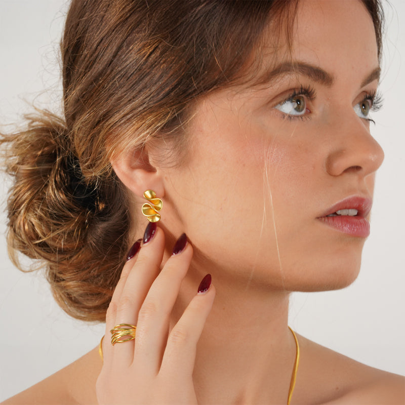 Twyla Earrings, 18K gold plated 925 silver earrings, shown worn on model's ear with matching ring and necklace visible.