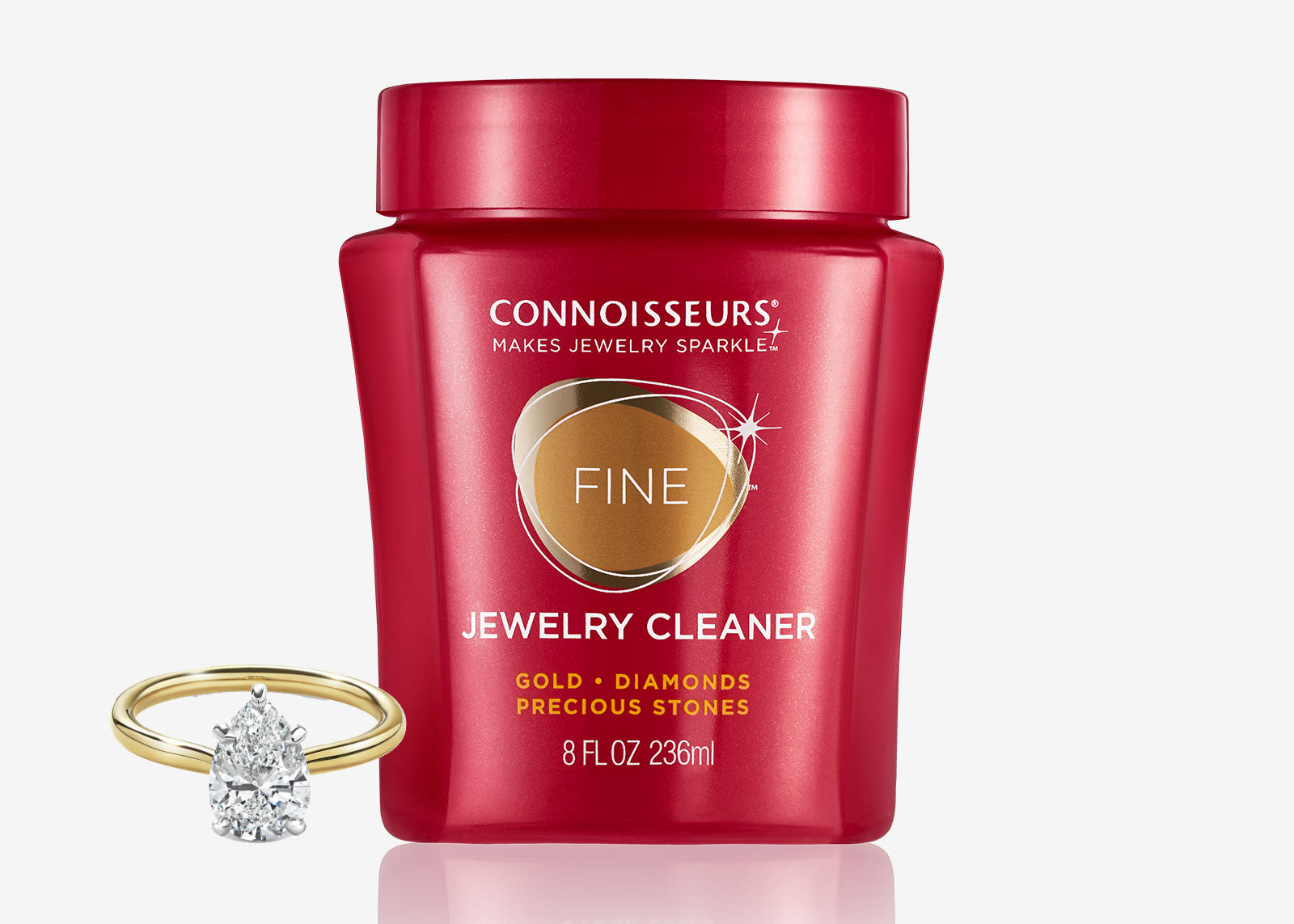 Red jar of Connoisseurs Fine Jewelry Cleaner with a diamond ring beside it, shown from the front.