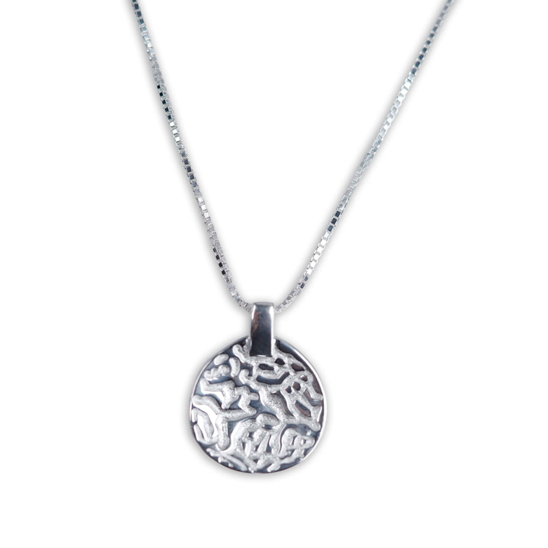 Orion Necklace, a 925 silver necklace with circular pendant featuring raised abstract pattern, shown flat lay.