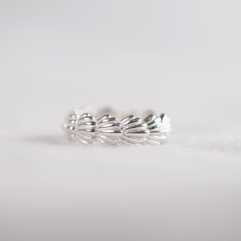 Shiloh Ring, a 925 silver ring with a twisted rope design, shown at an angle on a flat surface.