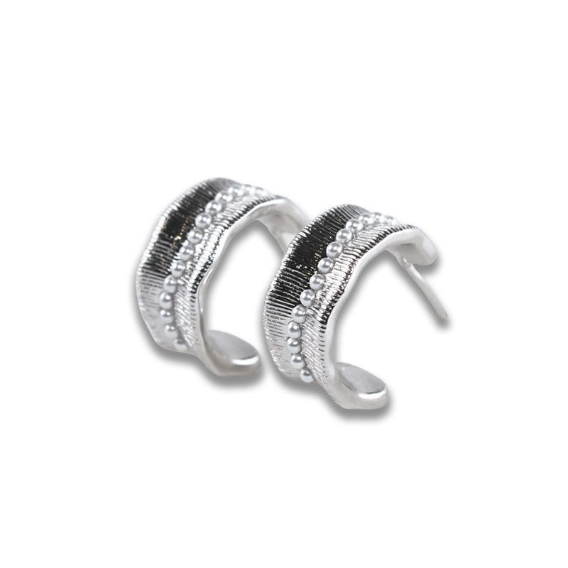 Lucian Earrings- Silver, a 925 silver pair of hoop earrings with textured bands and beaded detailing, shown from a side angle.