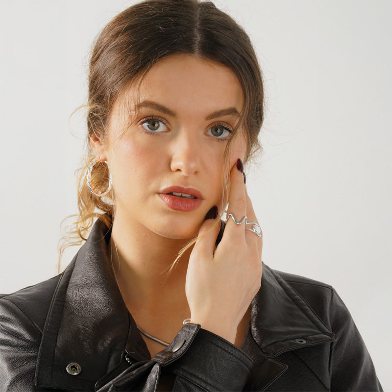 Milo Hoops- Silver, a 925 silver earring, shown worn on a model with a black leather jacket.