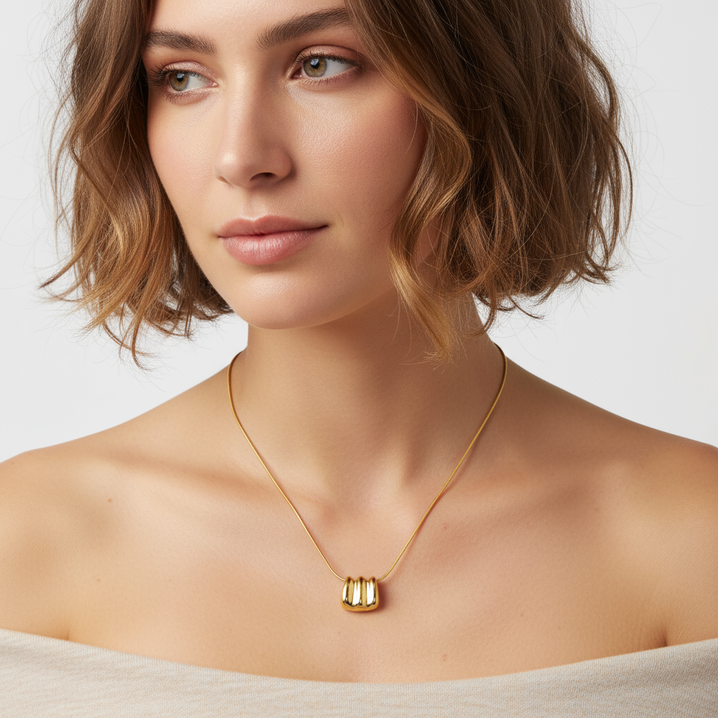 Gold Ripple Necklace, an 18K gold plated 925 silver necklace, shown on a model featuring a ridged pendant.