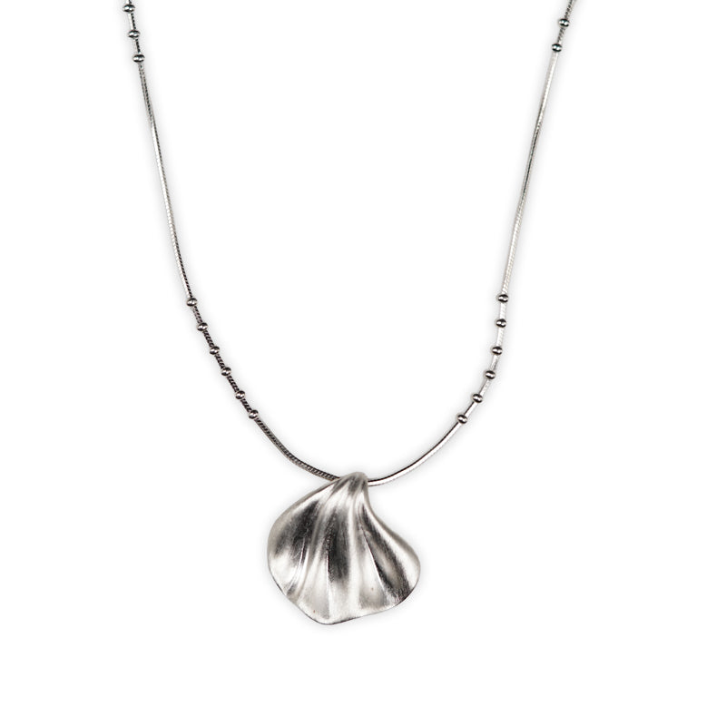 Rosalie Necklace, a 925 silver necklace with a sculptural shell-shaped pendant on a beaded chain, shown flat lay.