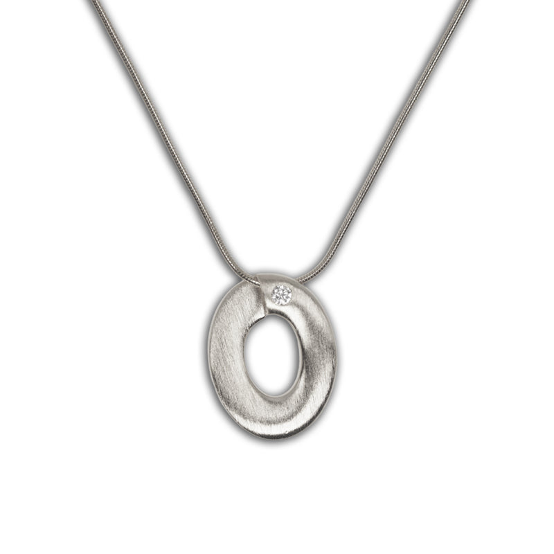 Ophelia Necklace in 925 silver with oval pendant featuring cutout center and small crystal accent, shown flat lay.
