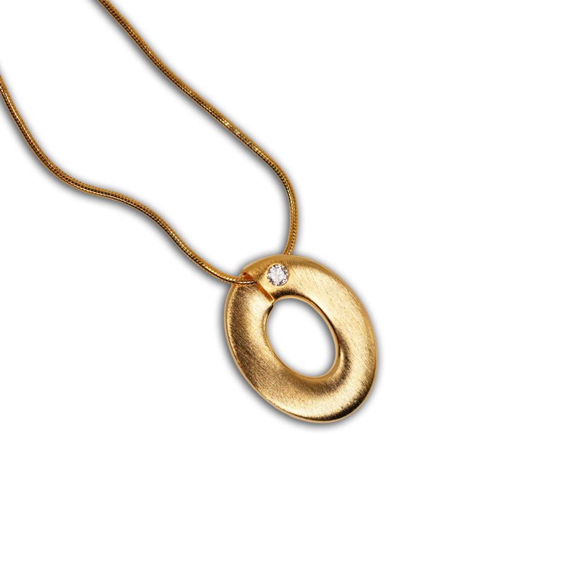 Ophelia Necklace in 18K gold plated 925 silver with oval pendant and small crystal accent, shown flat lay.