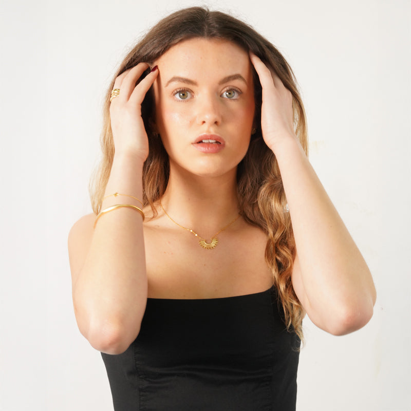 Inti Necklace, an 18K gold plated 925 silver necklace, shown on a model wearing a black top.