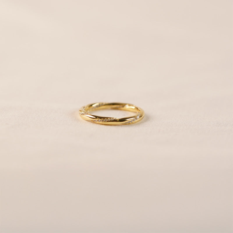 Venus Twisted Ring-Gold, an 18K gold plated 925 silver ring with a twisted textured design, shown at an angle on a neutral surface.