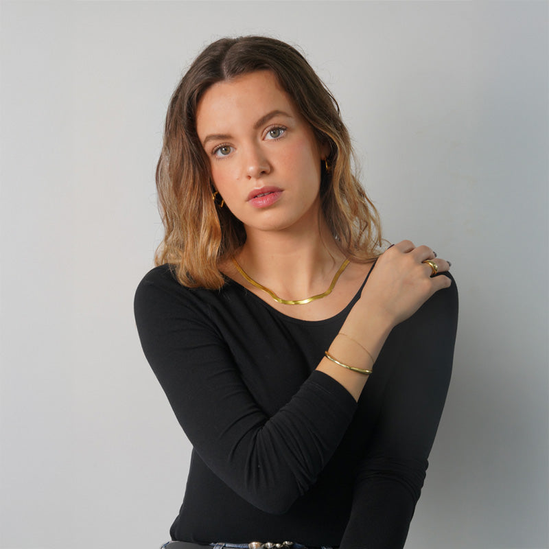 Cleo Snake Chain- Gold, an 18K gold plated 925 silver chain, shown worn on a model with matching jewelry.